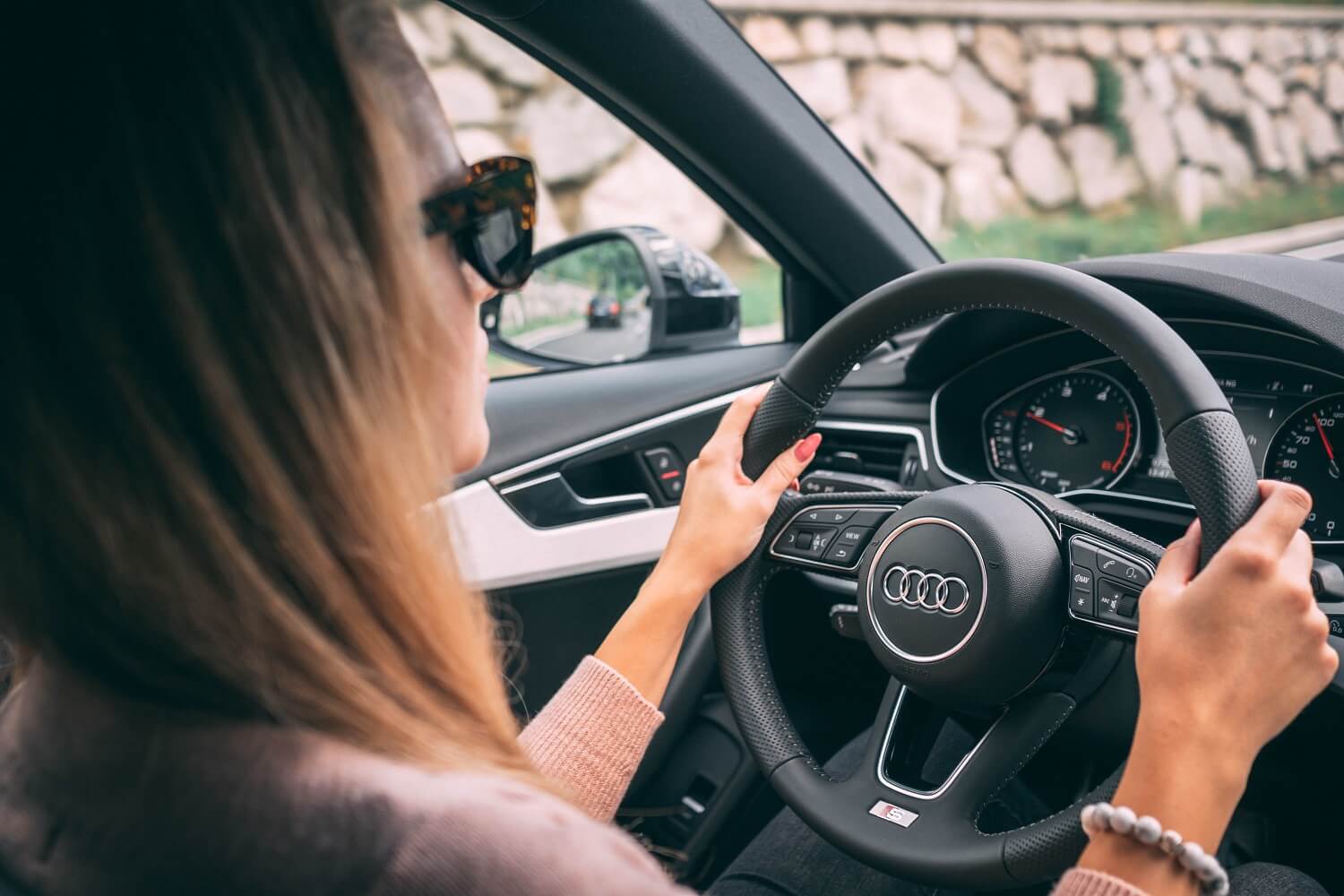 female business owner driving a car wearing sunglasses