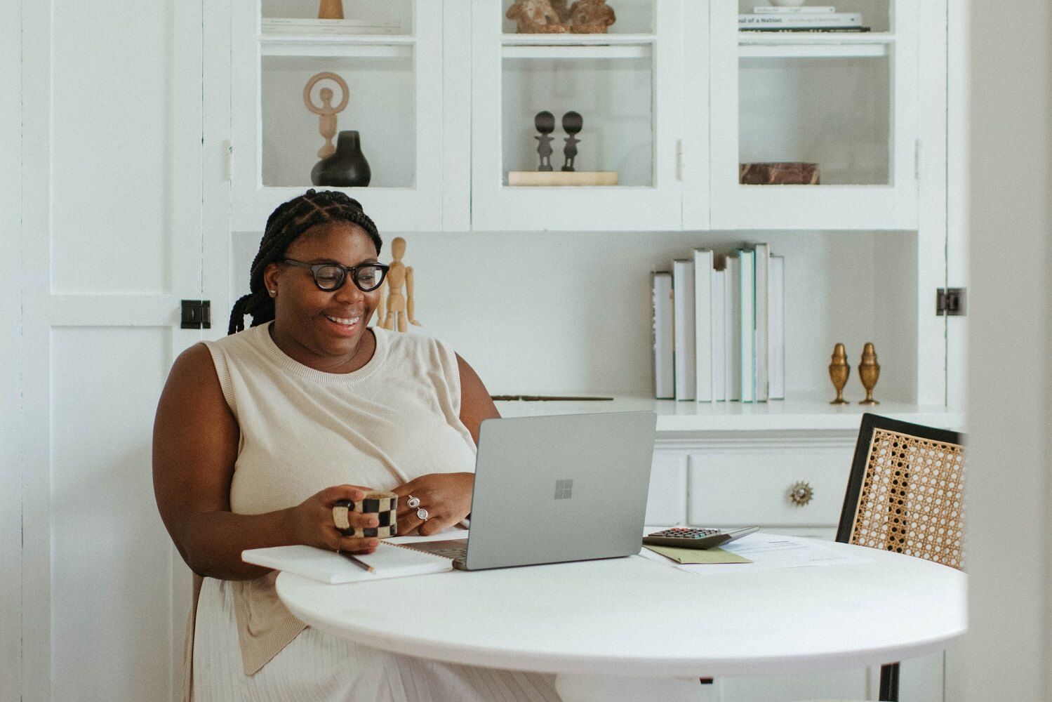 woman sat in her dining room researching business structures on a macbook